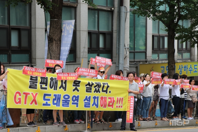 원흥지구 도래울마을 주민들이 주민설명회 시작 1시간 전부터 고양시청 정문에서 도래울역 신설을 요구하며 시위를 벌이고 있다.
