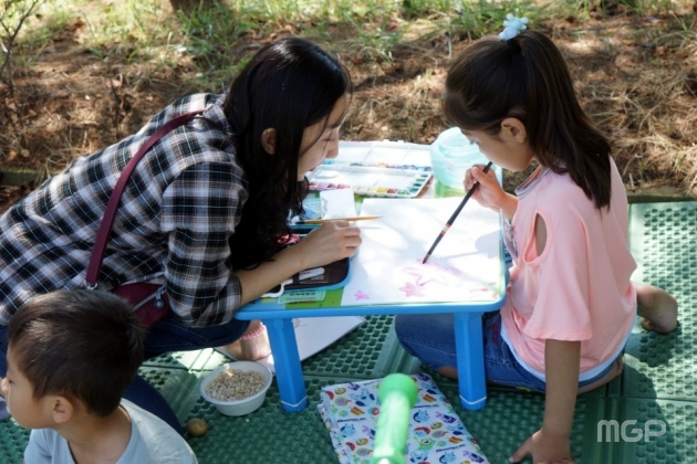 미술제에 참여한 어린이가 그림을 그리고 있다.