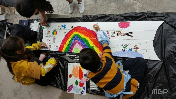 2018 헤이리 판 아트페스티벌의 참여 프로그램에 몰입한 방문가족 모습. 헤이리 사무국 앞에 설치 할 우드벤치에 그림을 그리고 있다.