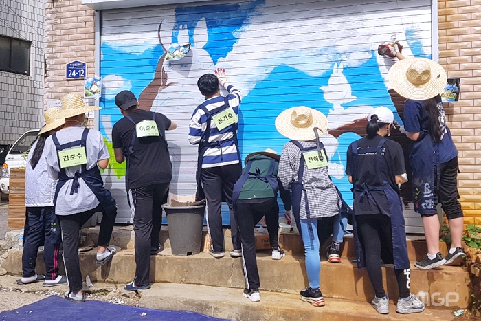 학생들이 벽화 그리기 봉사활동을 하고 있다.