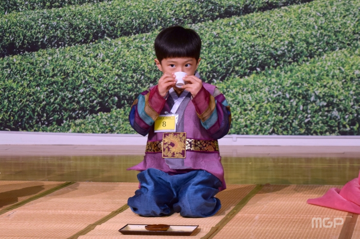 남자 어린이가 차를 마시고 있다.