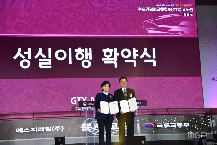 김현미 국토부 장관과 전병훈 에스지레일(주) 대표는 GTX를 본 딴 미니열차 앞에서 ‘성실이행 확약’을 인정하는 서명을 했다.