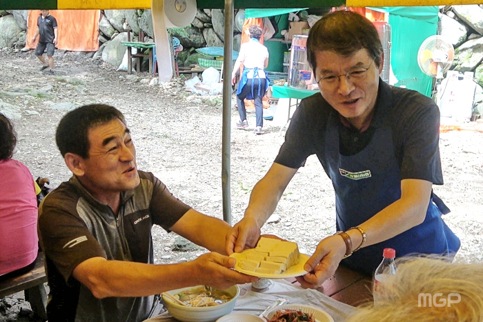 김진의 조합장이 산악회원들에게 식사를 대접하고 있다.
