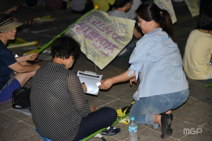 시위 중인 집회참가자에게 3기 신도시 철회 반대 서명을 받고 있다.