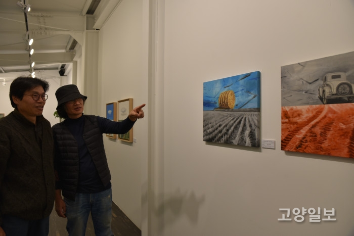 정인완(왼쪽) 화가와 한성수 대표가 3층에 전시된 정 화가의 작품을 감상하면서 대화를 나누고 있다.
