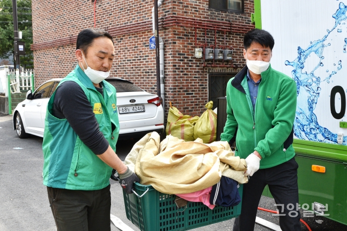 김창규 회장과 하우스케어 사업단 엄호용 단장이 세탁물을 옮기고 있다.