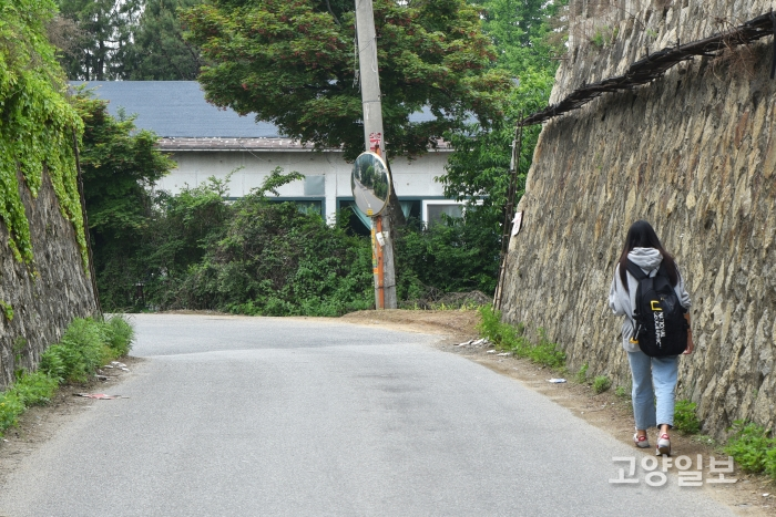 학생이 낙석이 있는 도로를 걷고 있다.